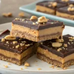 A close-up view of buckeye bars with a rich chocolate layer on top and a creamy peanut butter filling.