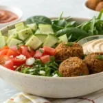 A colorful Falafel Bowl with crispy falafel, fresh vegetables, and tahini sauce.