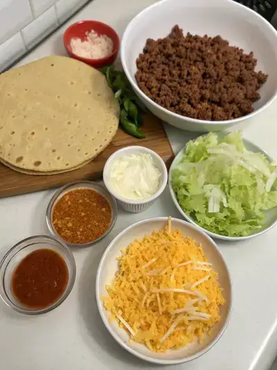 Ingredients for cheesy gordita crunch displayed on a kitchen table.