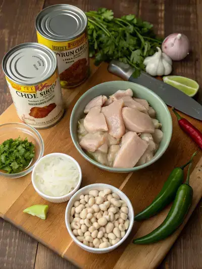 Ingredients for white chicken chili crockpot displayed on a kitchen table.