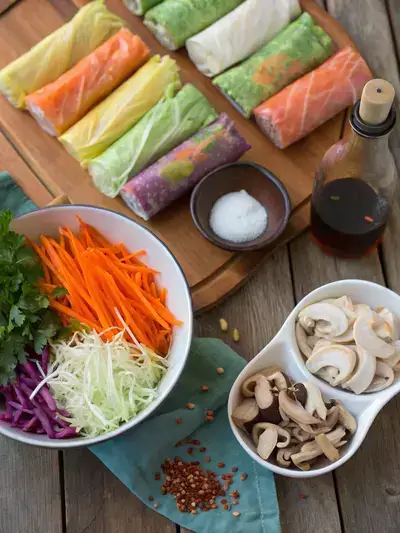 Fresh ingredients for making spring rolls on a kitchen table.