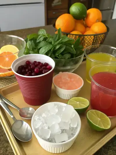 Ingredients for a Cranberry juice cocktail displayed on a kitchen table.