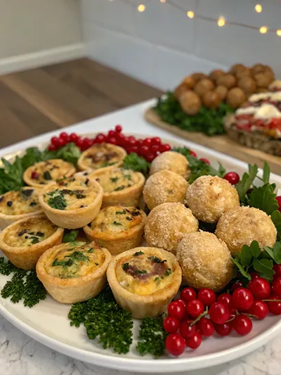 Christmas Eve appetizer table with puff pastry twists, baked brie, stuffed mushrooms, shrimp cocktail and bruschetta