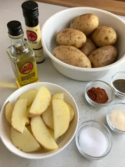 Ingredients for air fryer chips including potatoes, oil, salt, pepper, paprika, and garlic powder.
