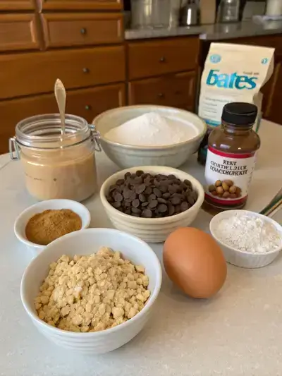 Ingredients for peanut butter oatmeal chocolate chip cookies arranged on a kitchen table.