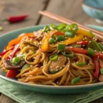 Delicious teriyaki noodles recipe served with vegetables and garnished with green onions and sesame seeds.